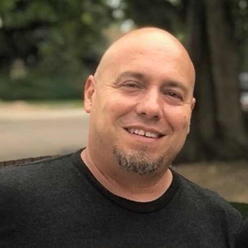 Ryan Bustos; short bald man with goatee.