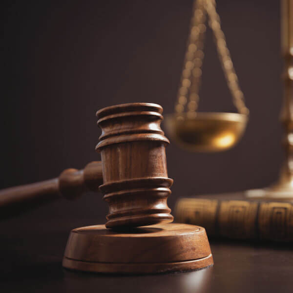 Hammer & gavel with justice scales in the background.